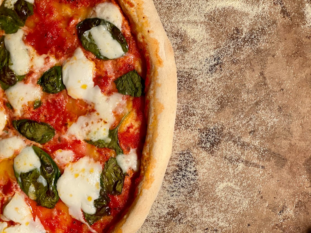 Fresh mozzarella melting over a Margherita pizza with tomato and basil