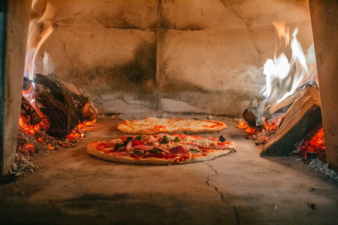 Neapolitan pizza baking in a hot stone oven with a blistered crust